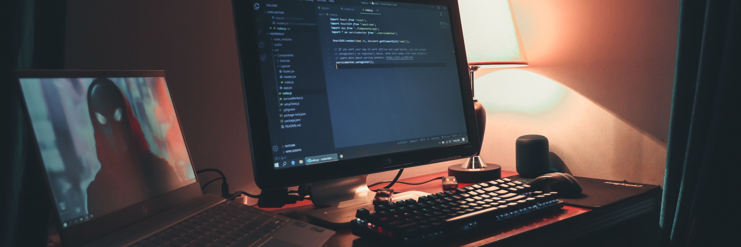 Escritório caseiro iluminado com dois monitores para codificação e programação.